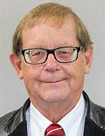 Man with beige hair and glasses smiling